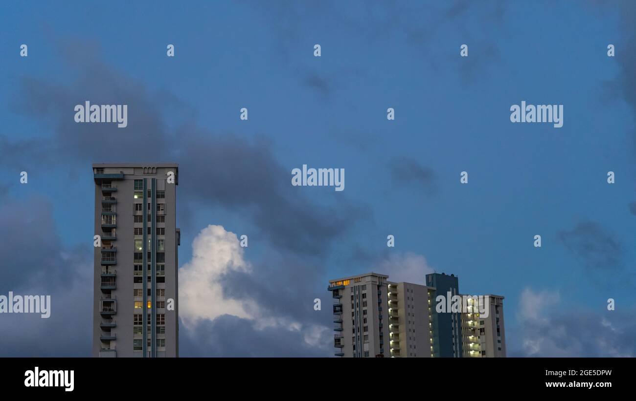 Alti condomini contro il cielo drammatico Foto Stock