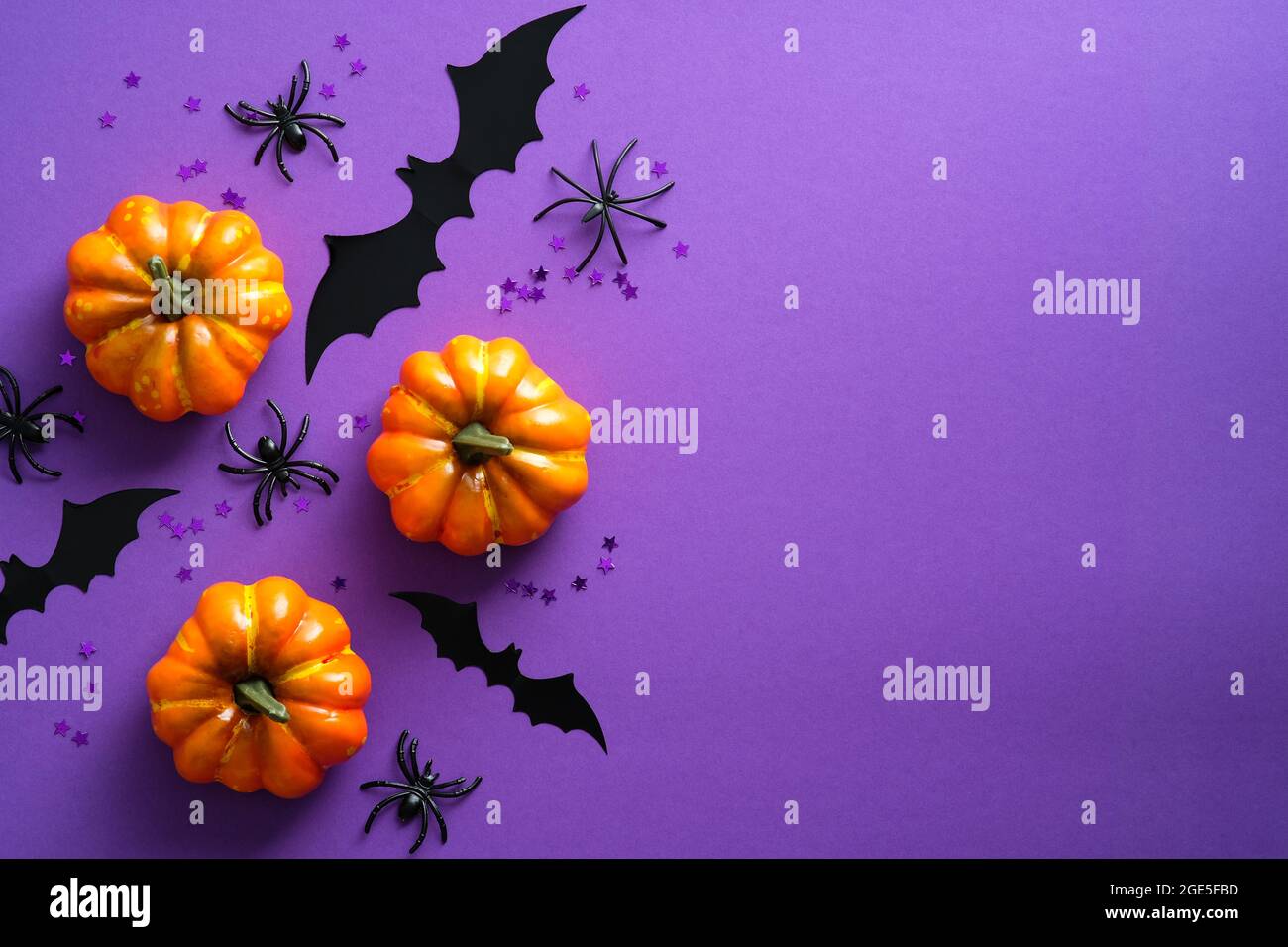 Buon concetto di vacanza di Halloween. Decorazioni di Halloween, zucche, pipistrelli, ragni su sfondo viola. Halloween party biglietto d'auguri mockup con copia s. Foto Stock