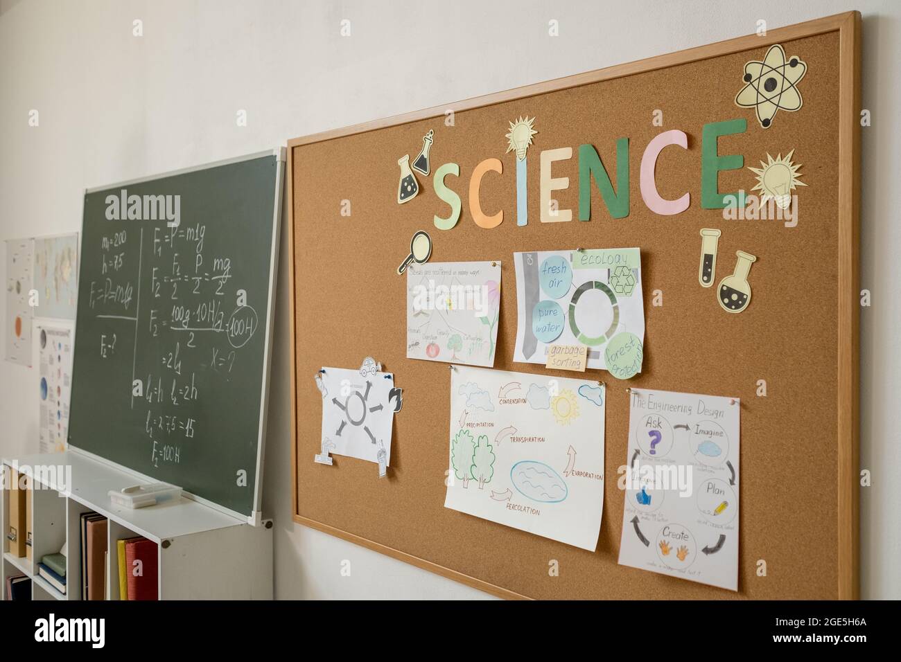Due lavagne con formule fisiche e documenti con punti di progetto all'interno della classe Foto Stock