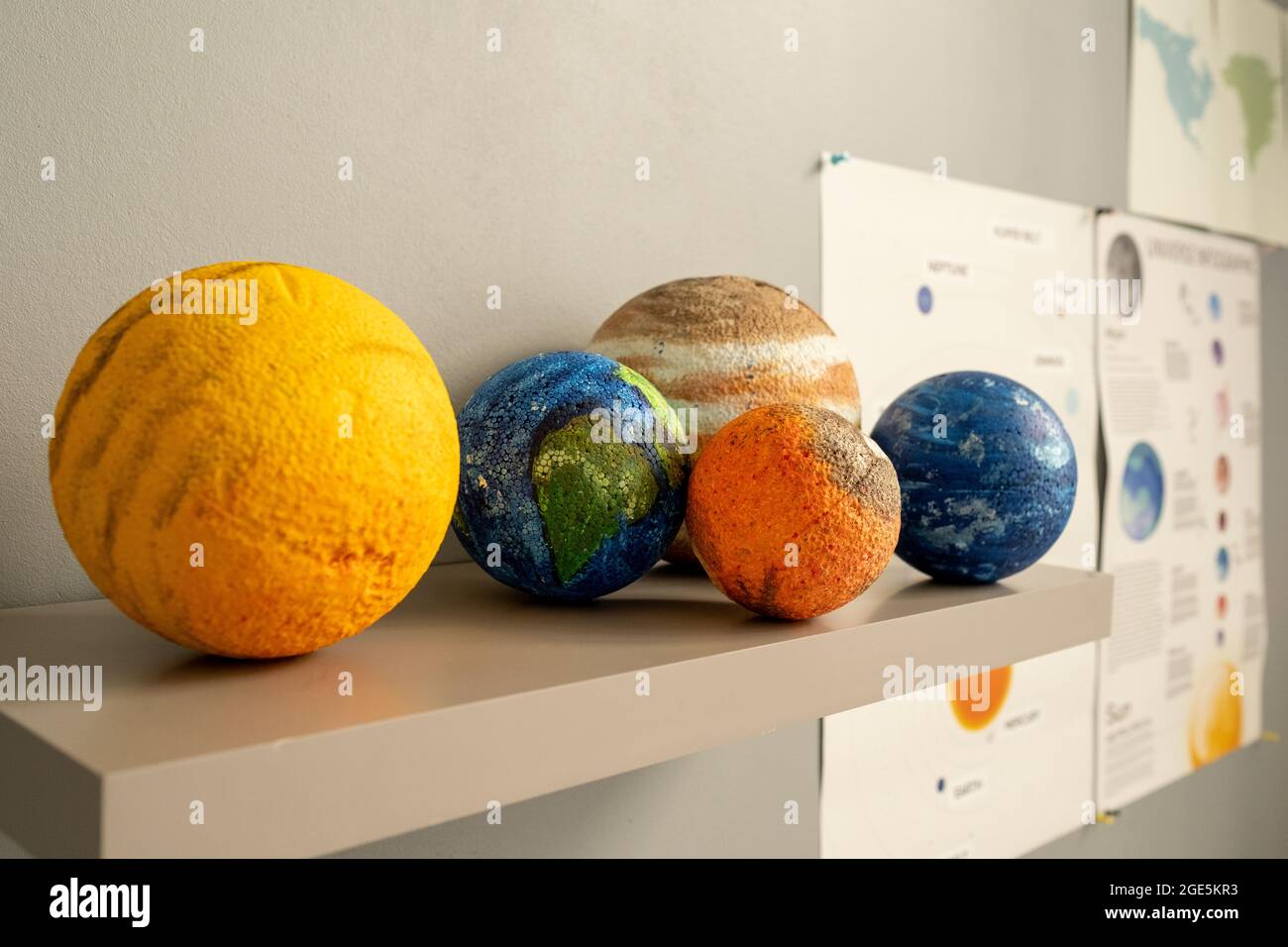 Gruppo di modelli planetari su scaffale da parete bianca all'interno dell'aula Foto Stock