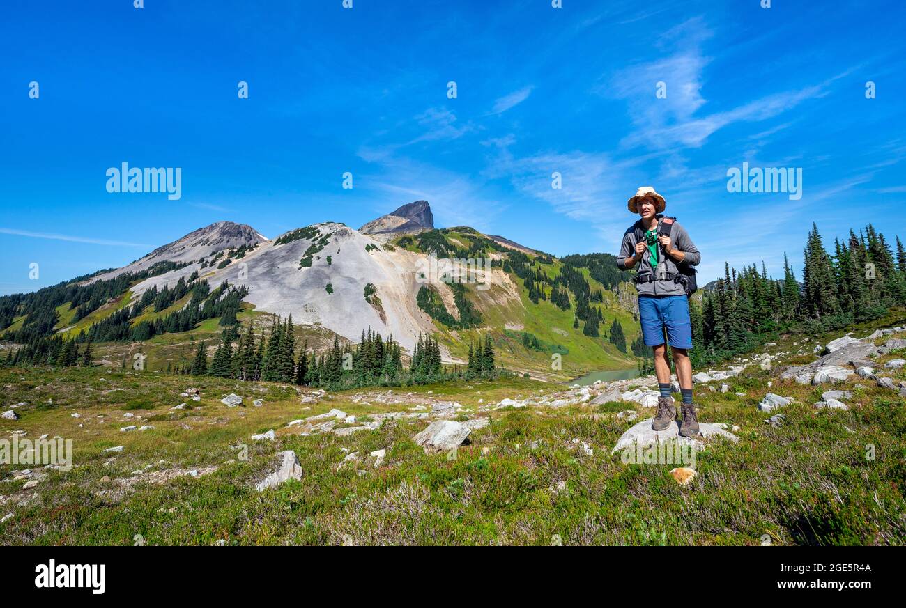 Escursionista che guarda la fotocamera, Black Tusk vulcanic mountain, Garibaldi Provincial Park, British Columbia, Canada Foto Stock