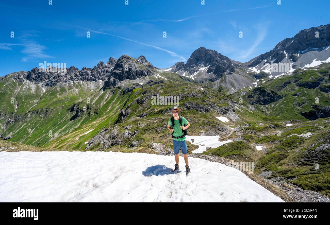 Escursionista in campo di neve, arrampicatore su sentiero escursionistico, sullo sfondo cime rocciose di Grosser Krottenkopf e Muttlerkopf, panorama montano, Heilbronner Foto Stock