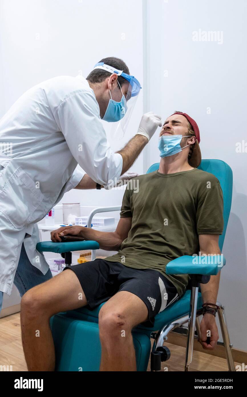 Medico in abbigliamento protettivo fa un test antigenico su un giovane uomo, test del coronavirus, Covid-19, Kalymnos, Grecia Foto Stock