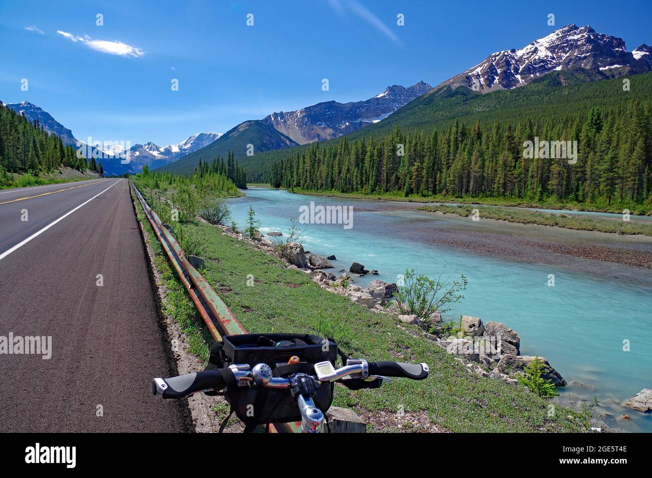 Manubrio di bicicletta di fronte a infinite strade, fiume e montagne innevate, vastità, avventura, Icefields Parkway, Alberta, Rocky Mountains, Canada Foto Stock