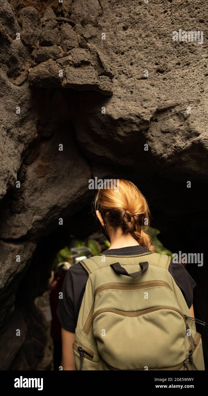 Una giovane donna entra in una grotta vulcanica a Lanzarote Foto Stock
