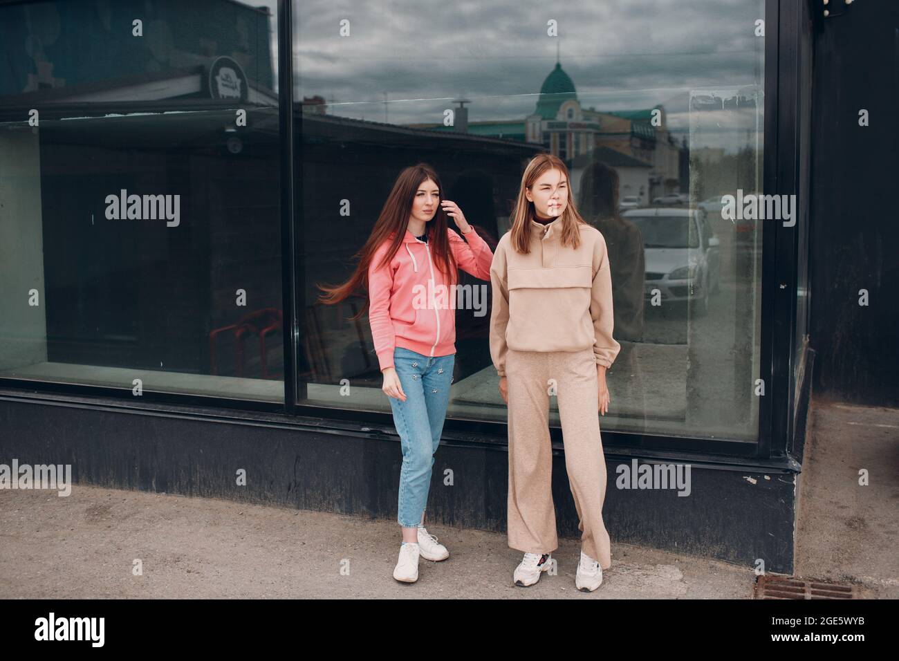 Due ragazze che camminano sulla strada della città. Giovane donna all'aperto Foto Stock