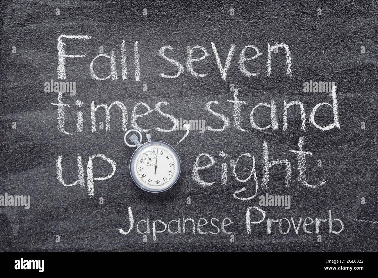 Cadono sette volte, levate in piedi su otto proverbio giapponese scritto sulla lavagna con cronometro vintage preciso Foto Stock
