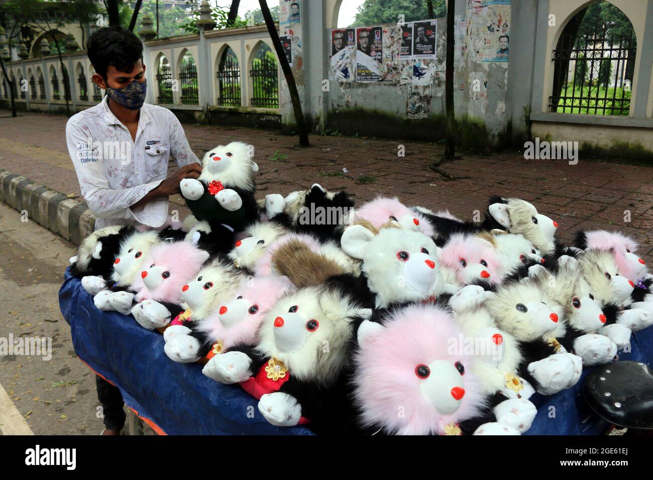 DHAKA, BANGLADESH - 13 AGOSTO: Una persona del Bangladesh, indossa una maschera protettiva mentre offre le figure del teddy ai visitatori sul lato della strada in mezzo alla pandemia di Covid-19. Il 13 agosto 2021 a Dhaka, Bangladesh. Credito: Eyepix Group/The Photo Access Foto Stock