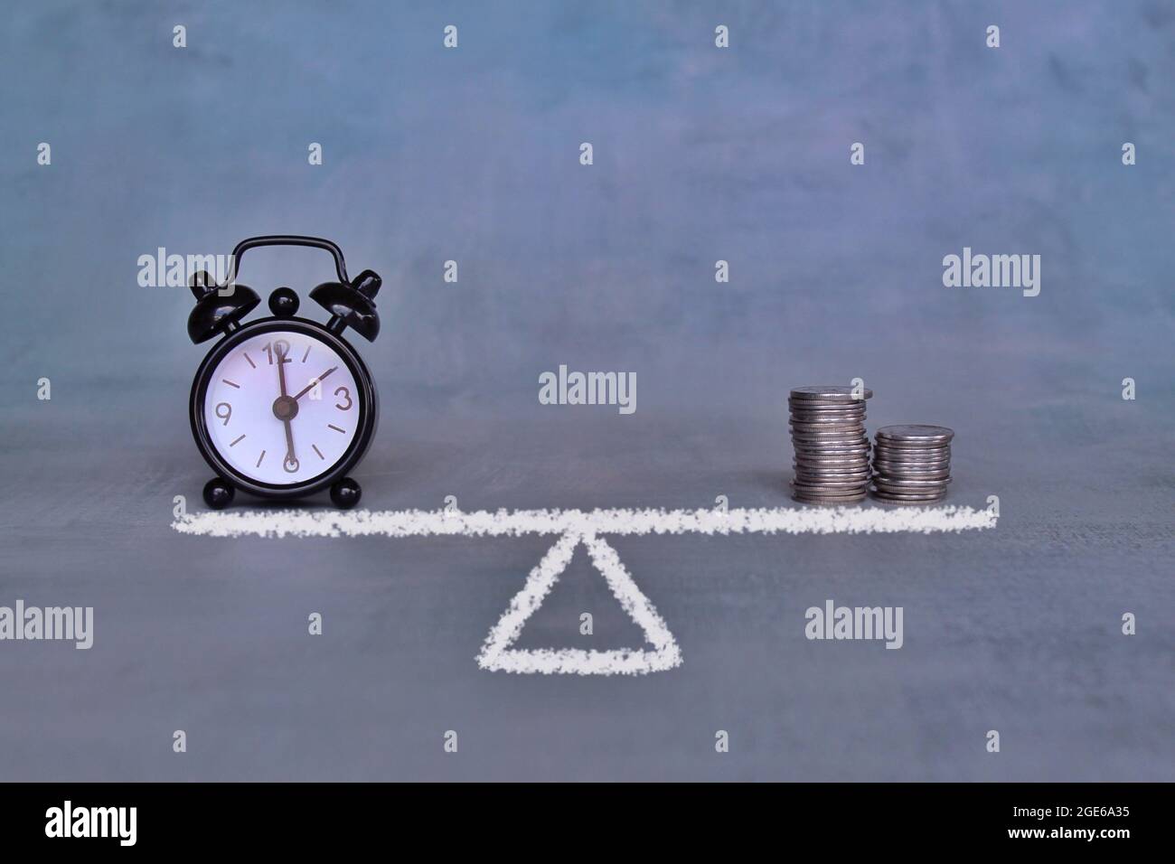 Equilibrio tra il concetto di tempo e denaro. Sveglia e pila monete su bilancia Foto Stock