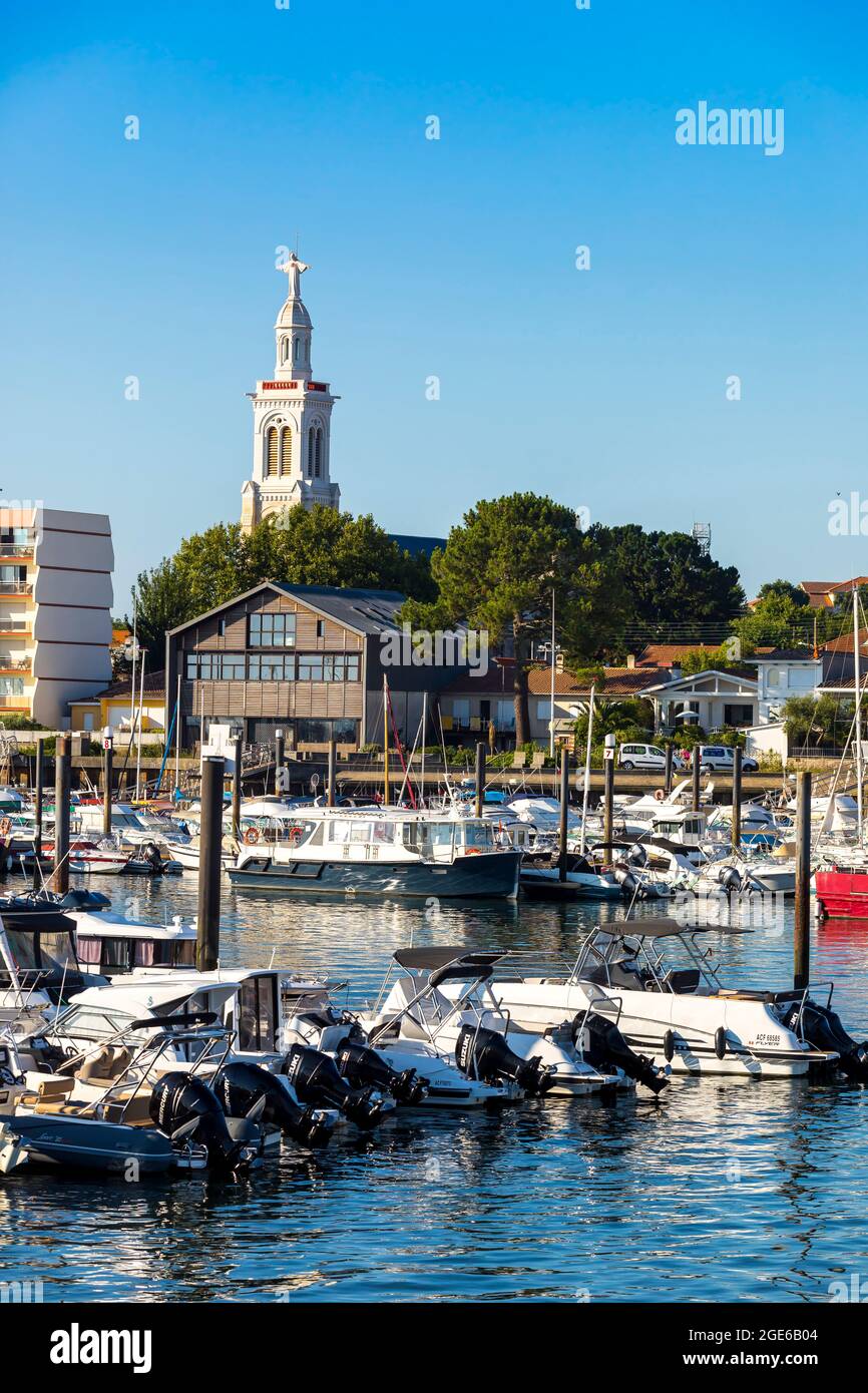 Arcachon (Francia sud-occidentale): Motoscafi e barche a vela nel porto turistico con edifici e casa lungo il lungomare, e campanile della Chiesa di SA Foto Stock