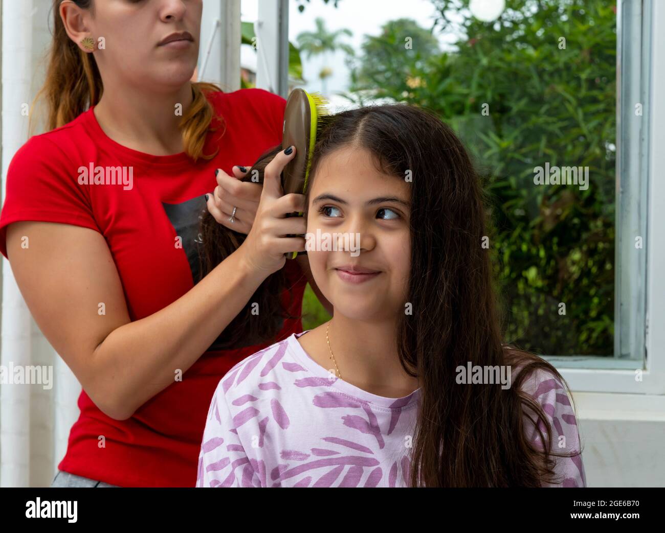 mamma che combatte i capelli di sua figlia nella camera da letto Foto Stock