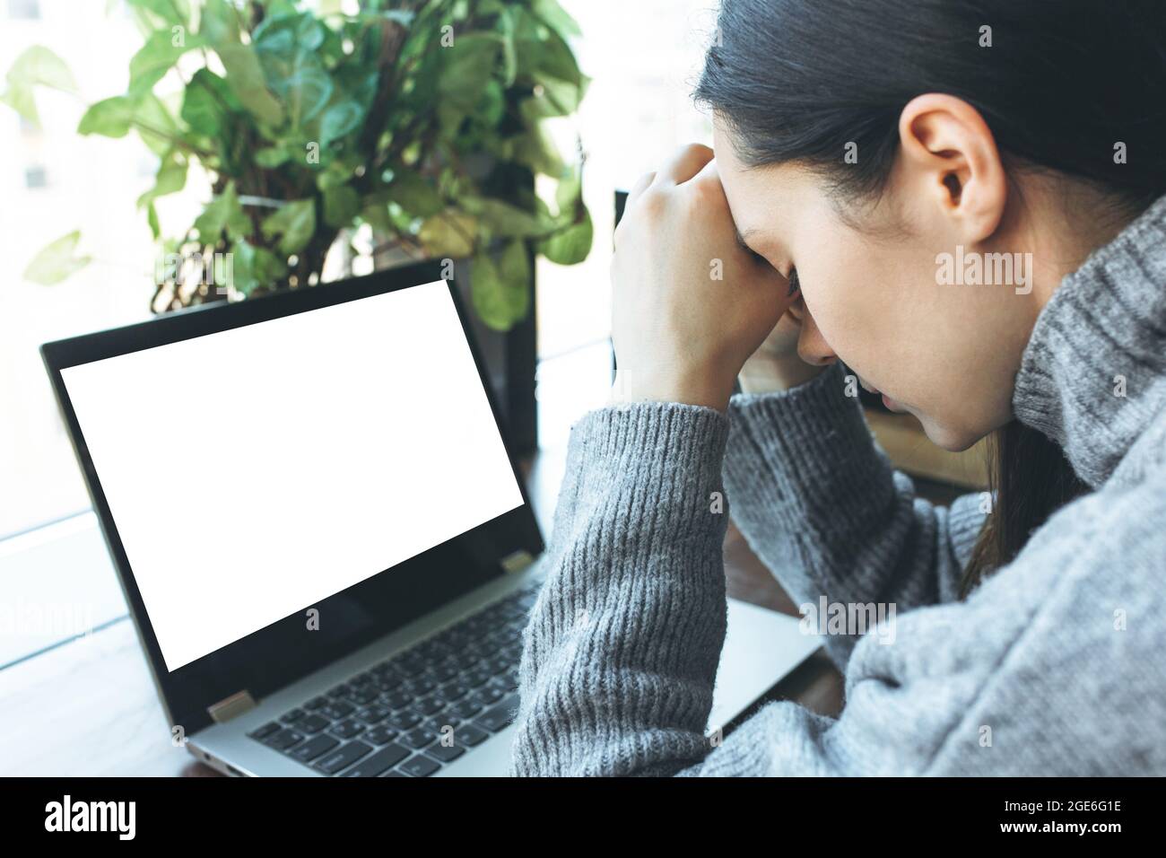 Esausto studente caucasico che lavora su un computer portatile, che soffre di mal di testa o emicrania. Foto Stock