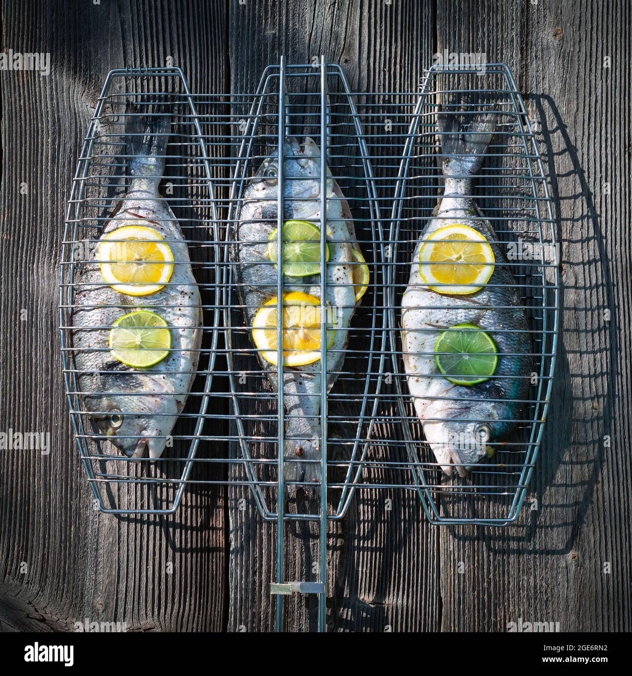 Preparato per grigliare il pesce dorada su tavola di legno. Fotografia alimentare Foto Stock