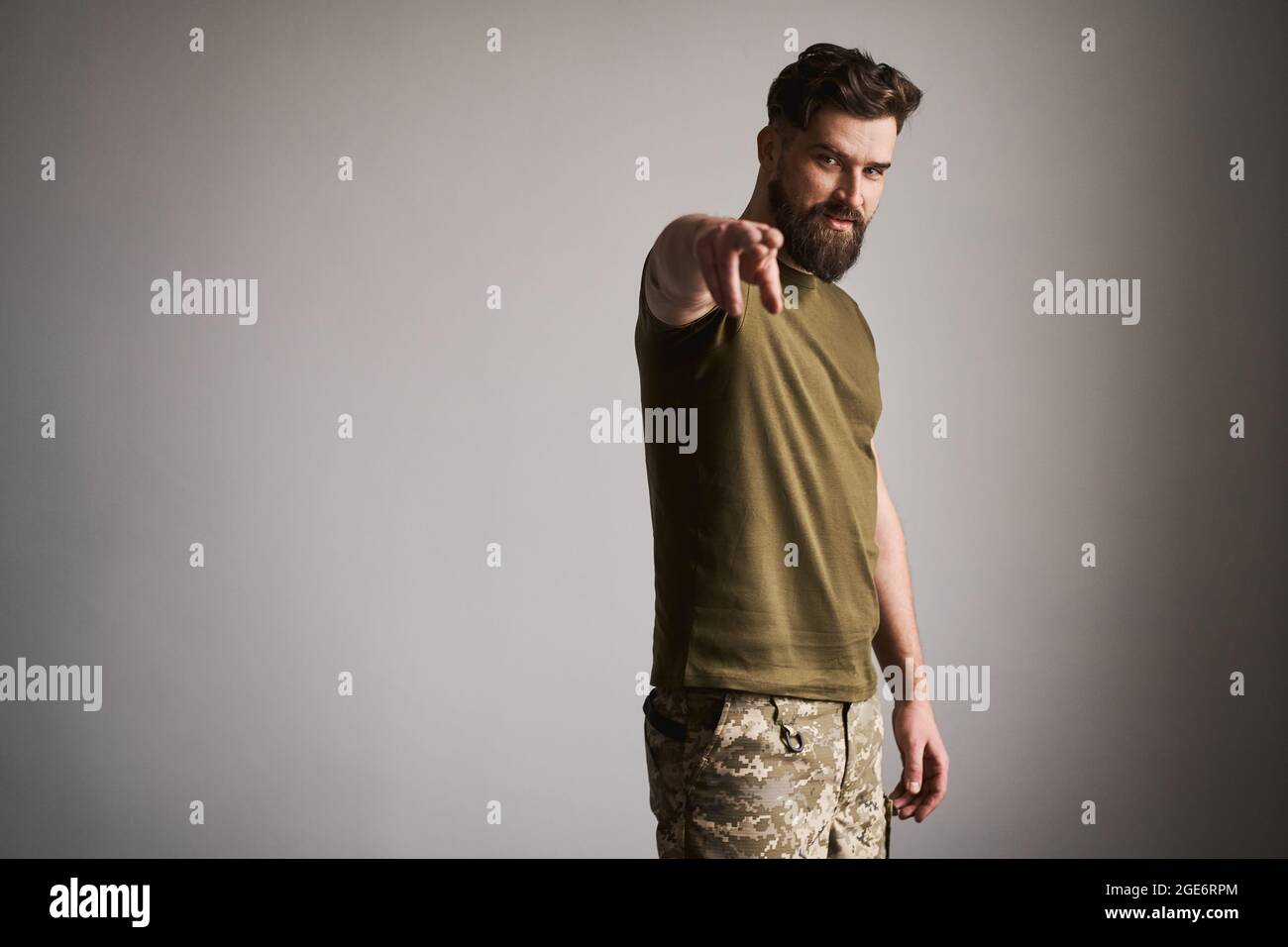 Uomo militare bearded che indossa uniforme e che mostra il gesto "ti sto guardando" Foto Stock