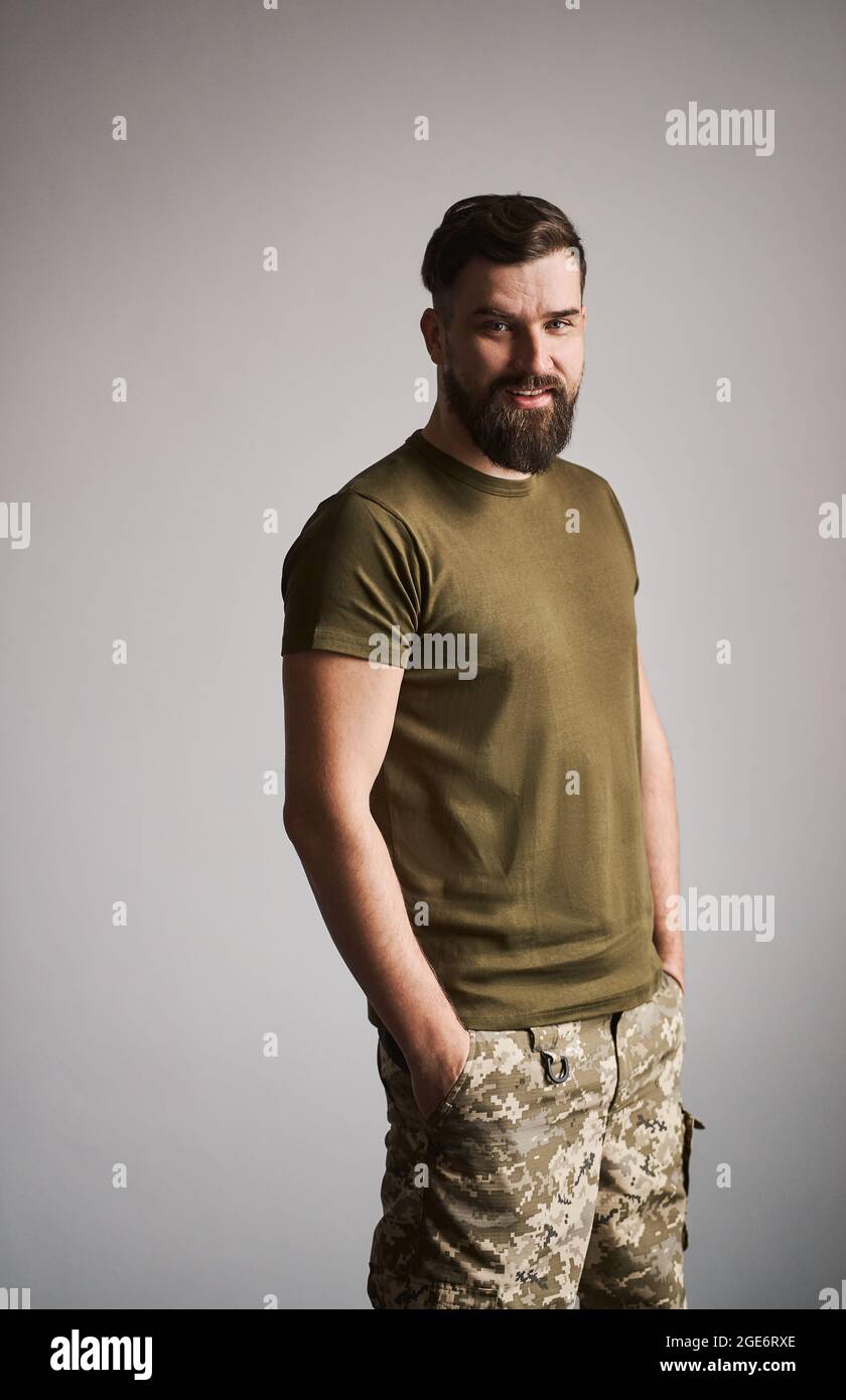 Ritratto di un servizioso militare in uniforme su sfondo grigio Foto Stock