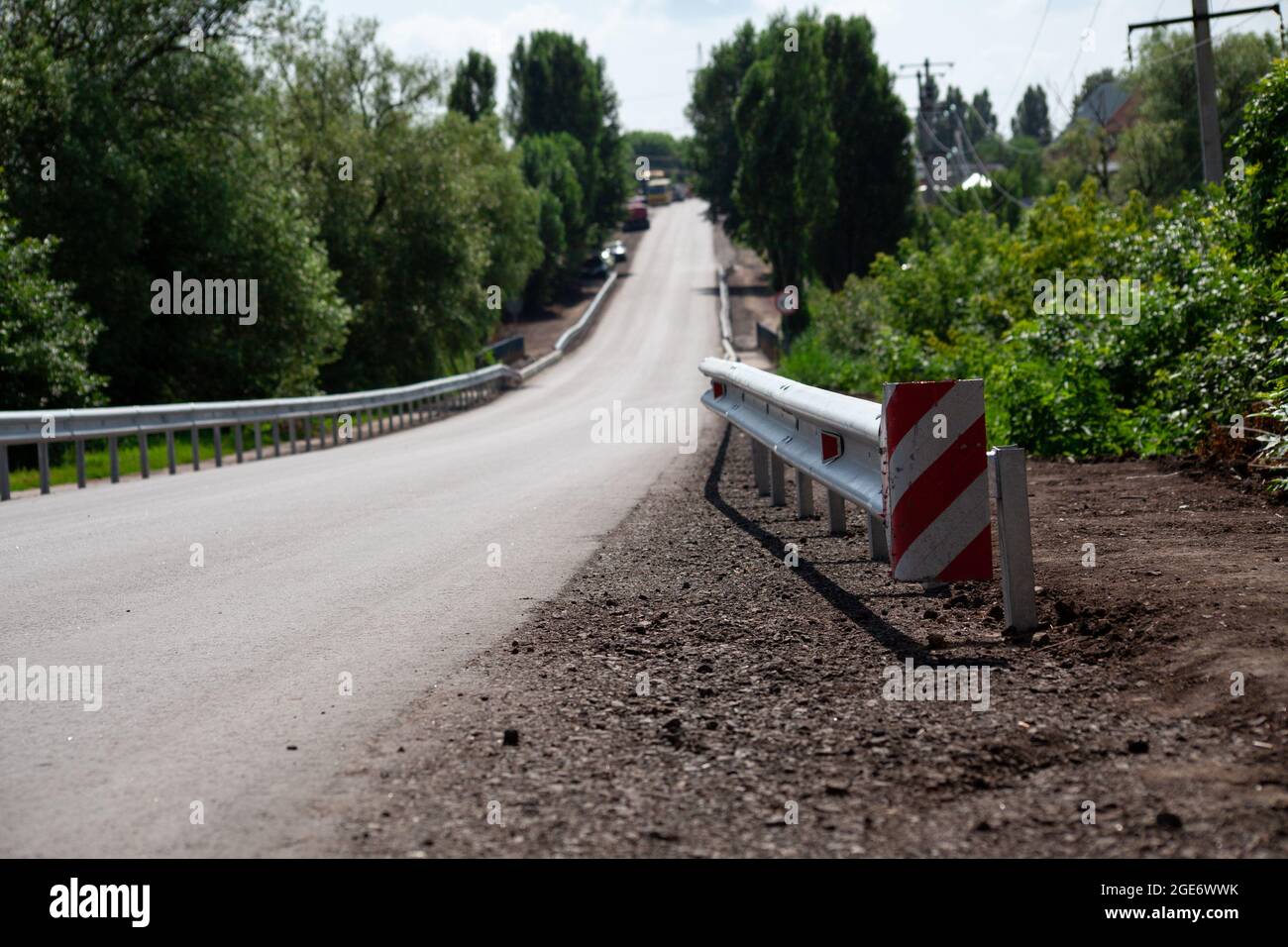 riflettori stradali rossi lungo la strada. recinzioni stradali in metallo di tipo barriera, primo piano. Sicurezza stradale e stradale. Vernice riflettente sul cartello. Barriera mediana Foto Stock