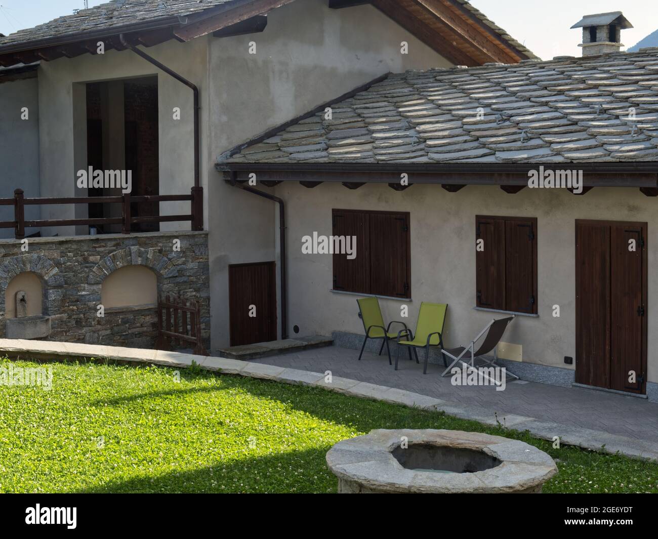 facciata e giardino di una bella residenza alpina con i tipici tetti in pietra Foto Stock