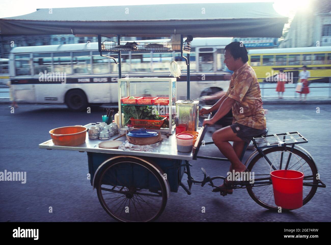 Malesia. Penang. L'uomo locale che pedala il suo triciclo di vendita di cibo. Foto Stock
