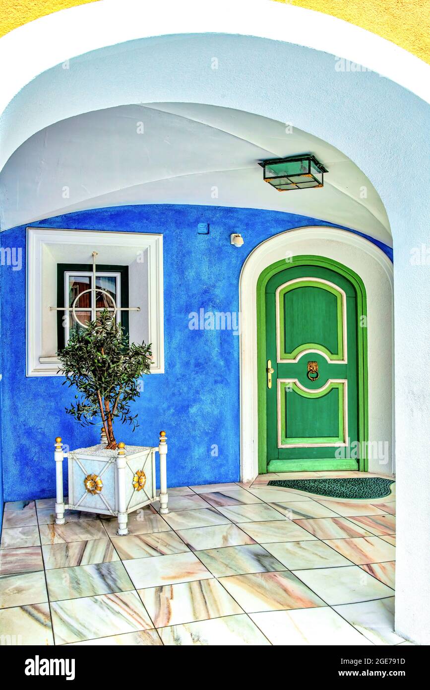 Bella area di ingresso mediterranea con porta verde, parete blu e porta bianca e ornamenti di finestre Foto Stock