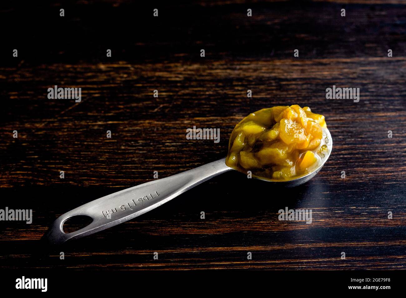 Cucchiaio da tavola di peperoni verdi in patta: Un misurino riempito con peperoncini verdi a dadini del New Mexico Foto Stock