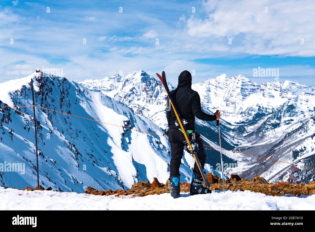 Uomo con sci e polo di sci al Summit of Massive Winter Mountain Landscape Foto Stock