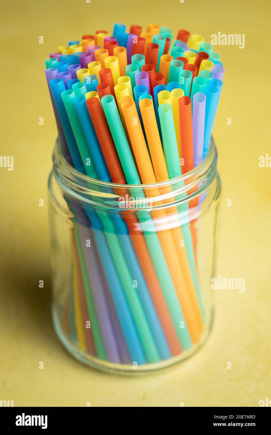 Pila di cannucce colorate in plastica in un vaso di vetro Foto Stock