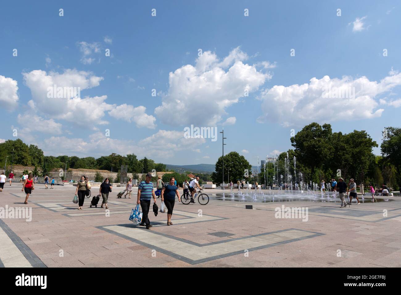 NIS, Serbia - 14 agosto 2021 Piazza della città con pavimento lastricato e fontana, la gente che cammina in una calda giornata estiva soleggiata nella città di Nis Foto Stock