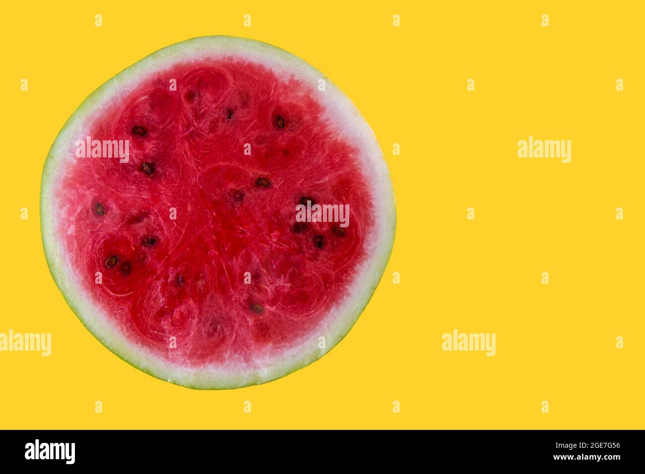 metà di cocomero fresco isolato su sfondo giallo, sezione trasversale con spazio di copia Foto Stock