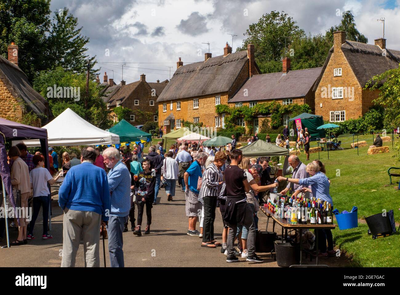 Regno Unito, Inghilterra, Oxfordshire, Wroxton, festa annuale della chiesa in corso, visitatori tra le bancarelle in Main Street, al bordo del villaggio verde Foto Stock