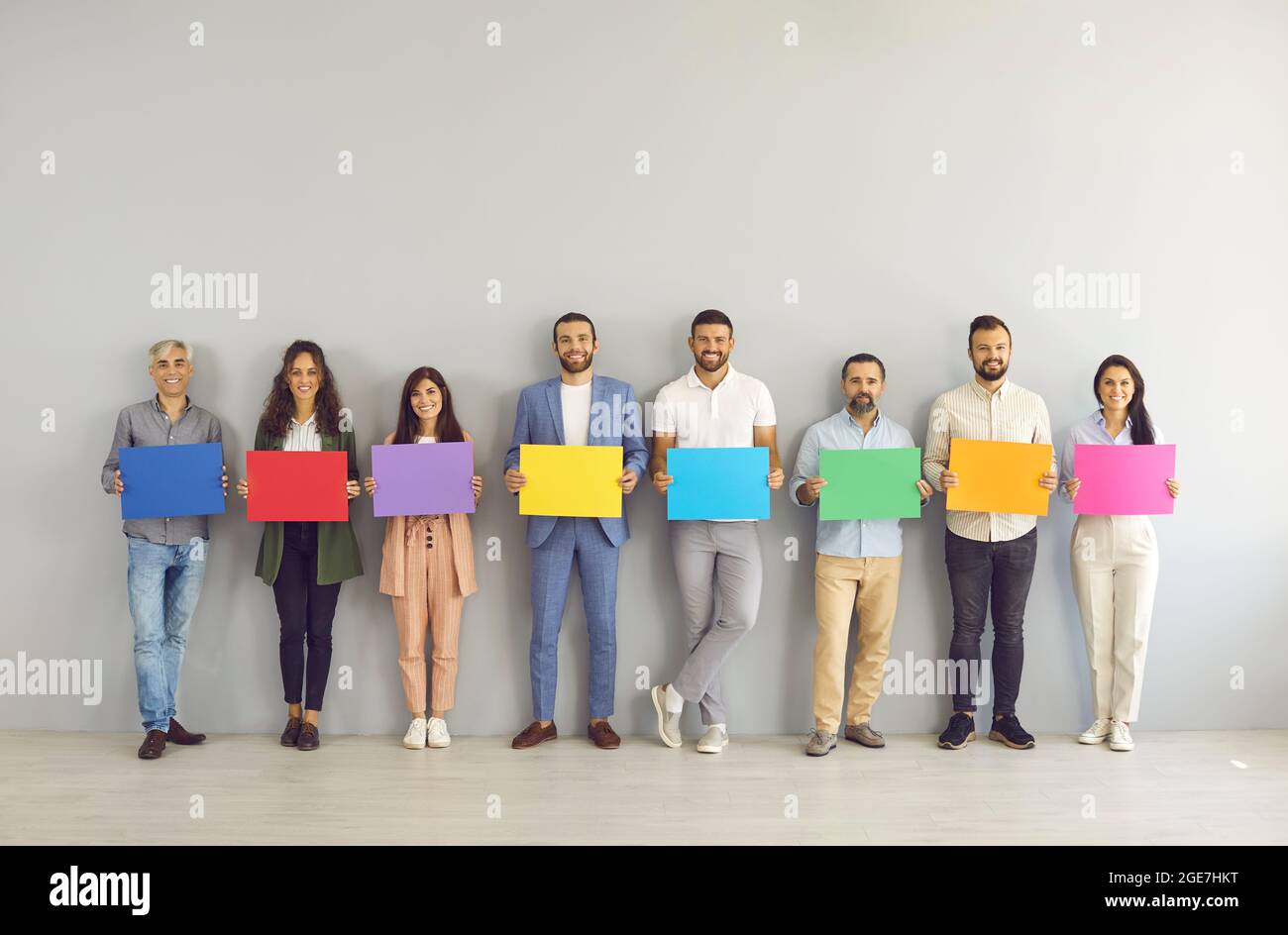 Gruppo di persone felici di affari in piedi in ufficio e tenere banners di carta mockup Foto Stock
