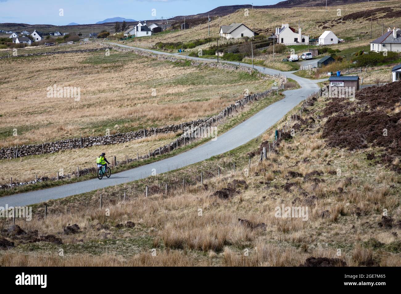 Un ciclista solitario sulla strada a Waternish, Isola di Skye, Scozia. Foto Stock