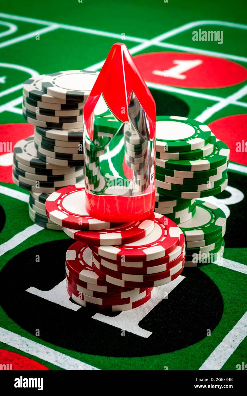 Casino gioco d'azzardo, dipendenza ai giochi d'azzardo e roulette concetto di numero fortunato con marcatore di vittoria (chiamato un Dolly) piazzato su una pila di chip sulla vittoria Foto Stock