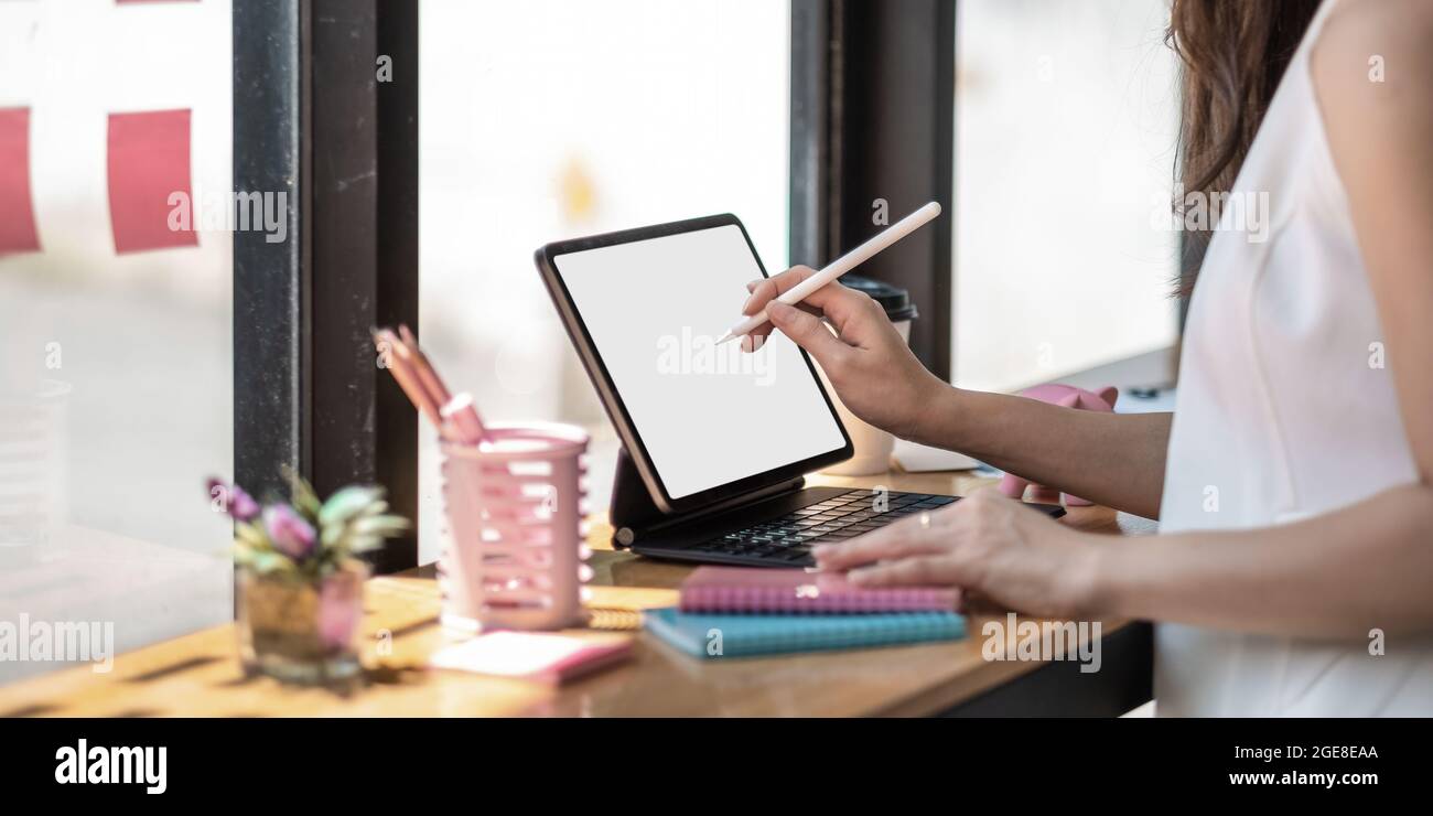 Donna asiatica mano che tiene la penna stilo scrittura su un computer tablet digitale. Primo piano Foto Stock