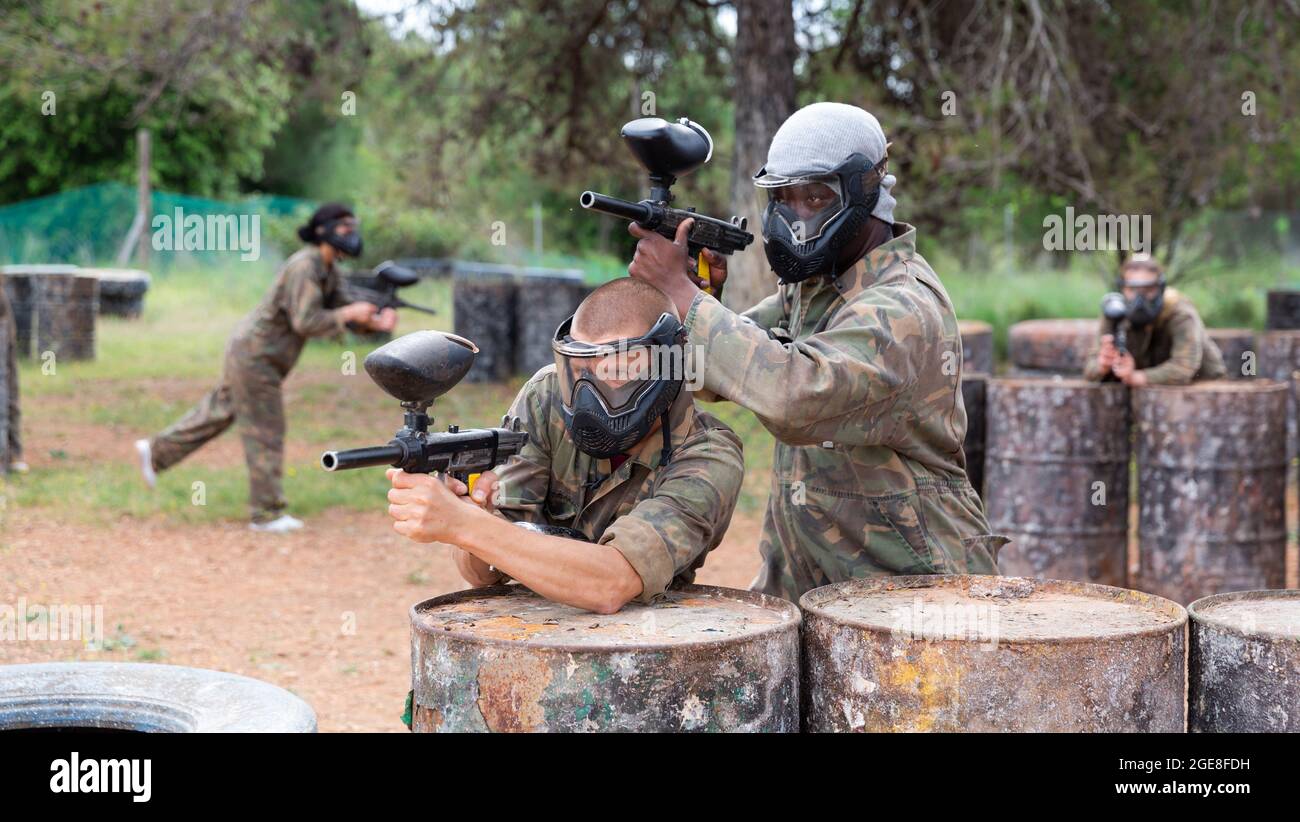 Due paintball giocatore in camouflage e maschera di mira con pistola in sparo Foto Stock