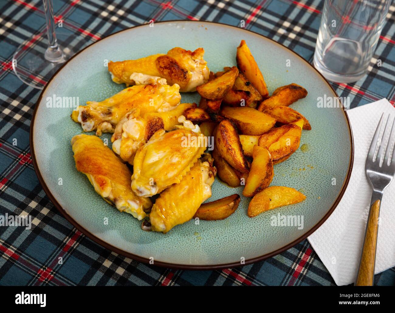Ali di pollo fritte al barbecue con patate al forno Foto Stock
