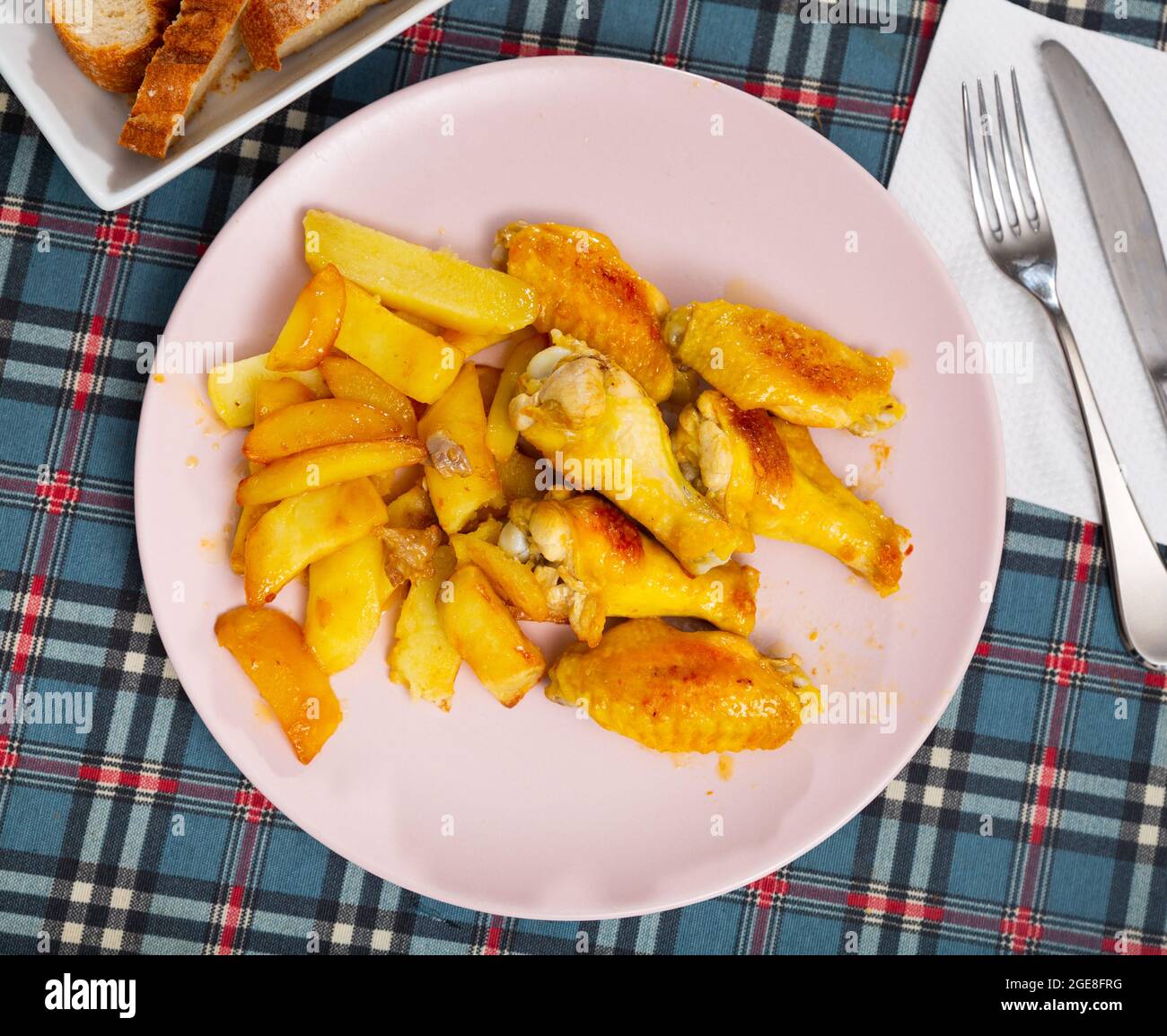 Ali di pollo fritte al barbecue con patate al forno Foto Stock