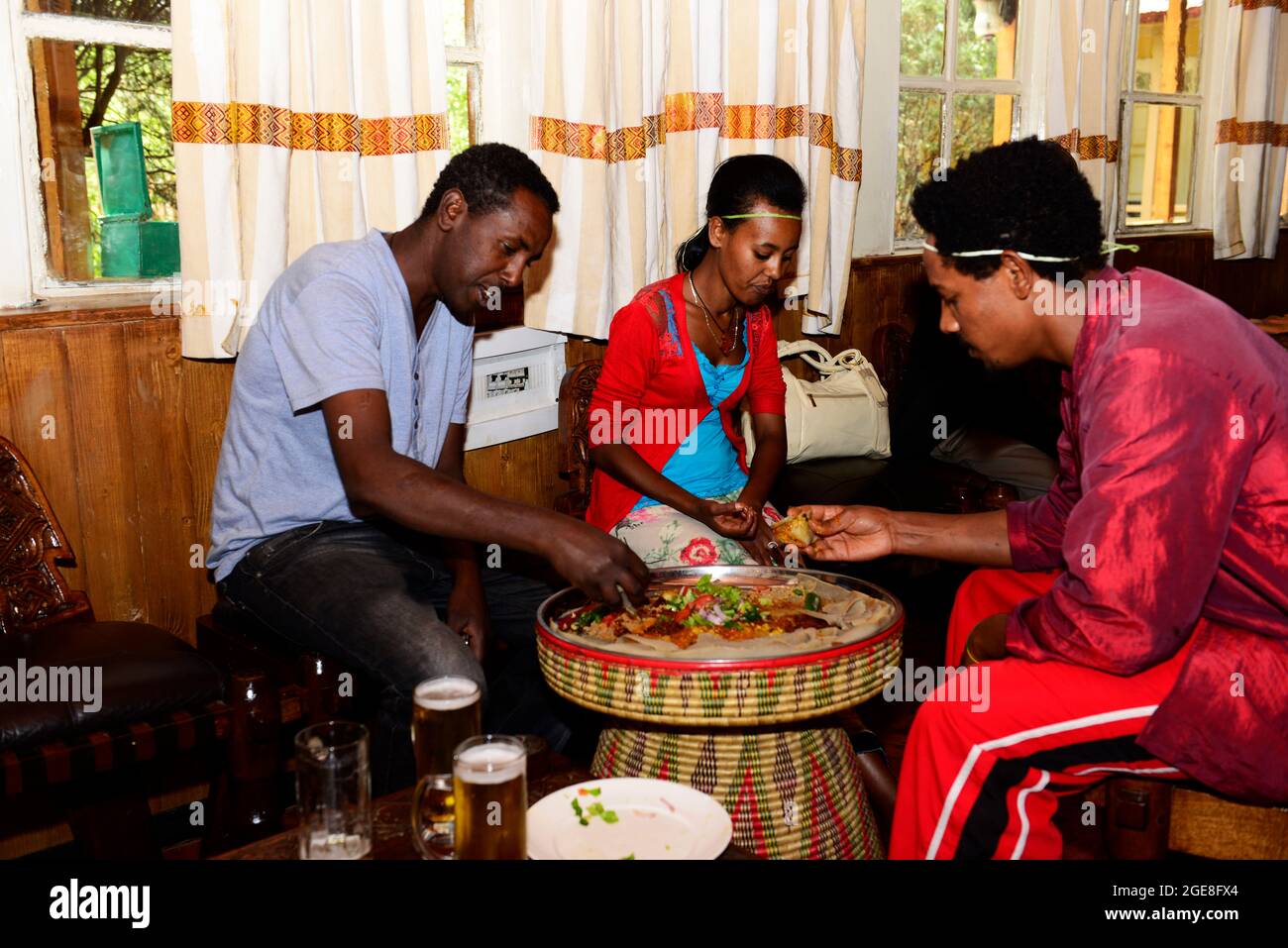 Gli etiopi mangiano insieme un piatto injera al ristorante culturale Finfine ad Addis Abeba, Etiopia. Foto Stock