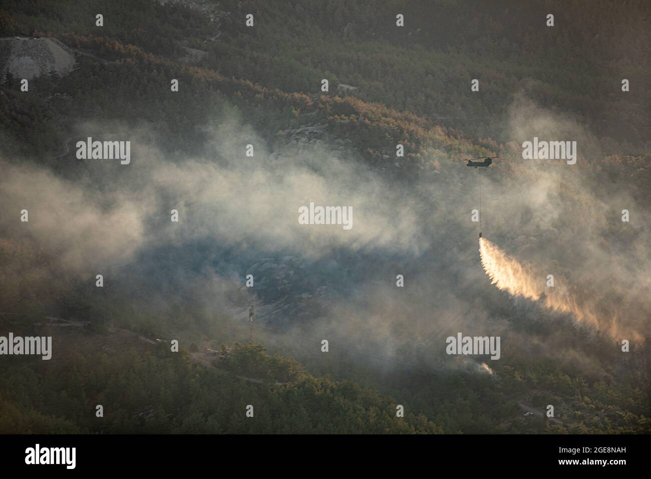 Gli equipaggi dell'esercito degli Stati Uniti assegnati a Bravo Company, 1° Battaglione, 14° Reggimento dell'aviazione, 12° Brigata dell'aviazione di combattimento, rilasciano acqua da un secchio attaccato a un Chinook CH-47 mentre l'equipaggio vola nella Turchia occidentale durante una missione di lotta aerea il 15 agosto 2021. E' la prima volta che molti membri dell'equipaggio combattono incendi. (STATI UNITI Esercito foto di staff Sgt. Christopher Stewart) Foto Stock
