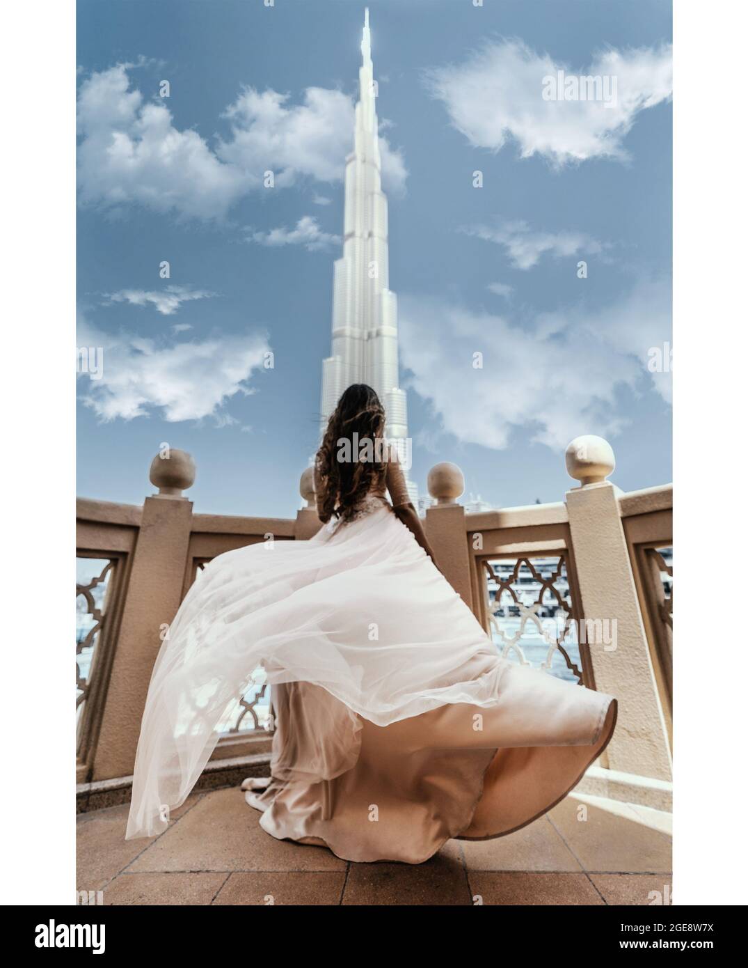Scatto verticale di una femmina in piedi su un balcone e ammirando una bella torre di Burj Khalifa Foto Stock