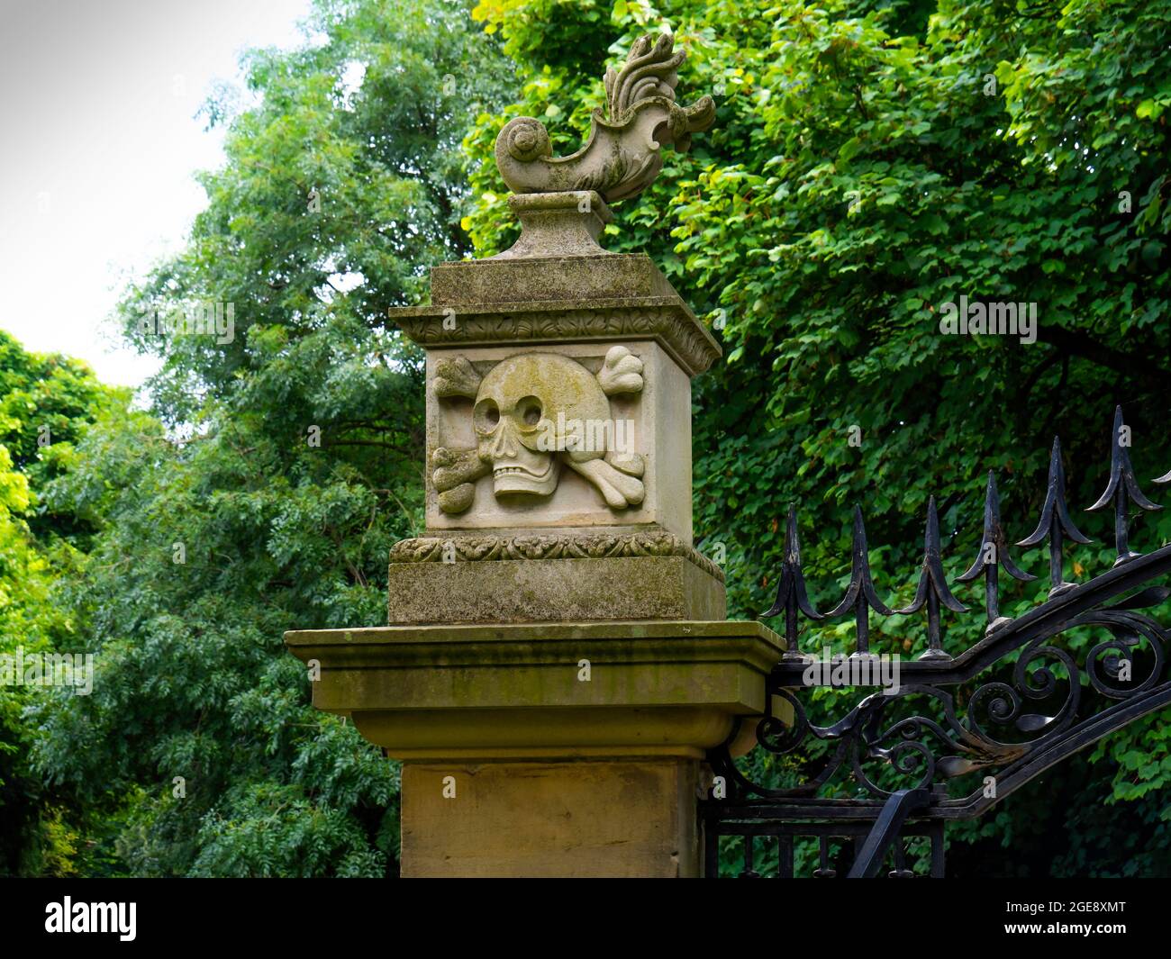 Scultura in pietra raffigurante un cranio e crossoni sul cancello d'ingresso della chiesa di St Cuthberts Kirkleatham North Yorkshire Foto Stock