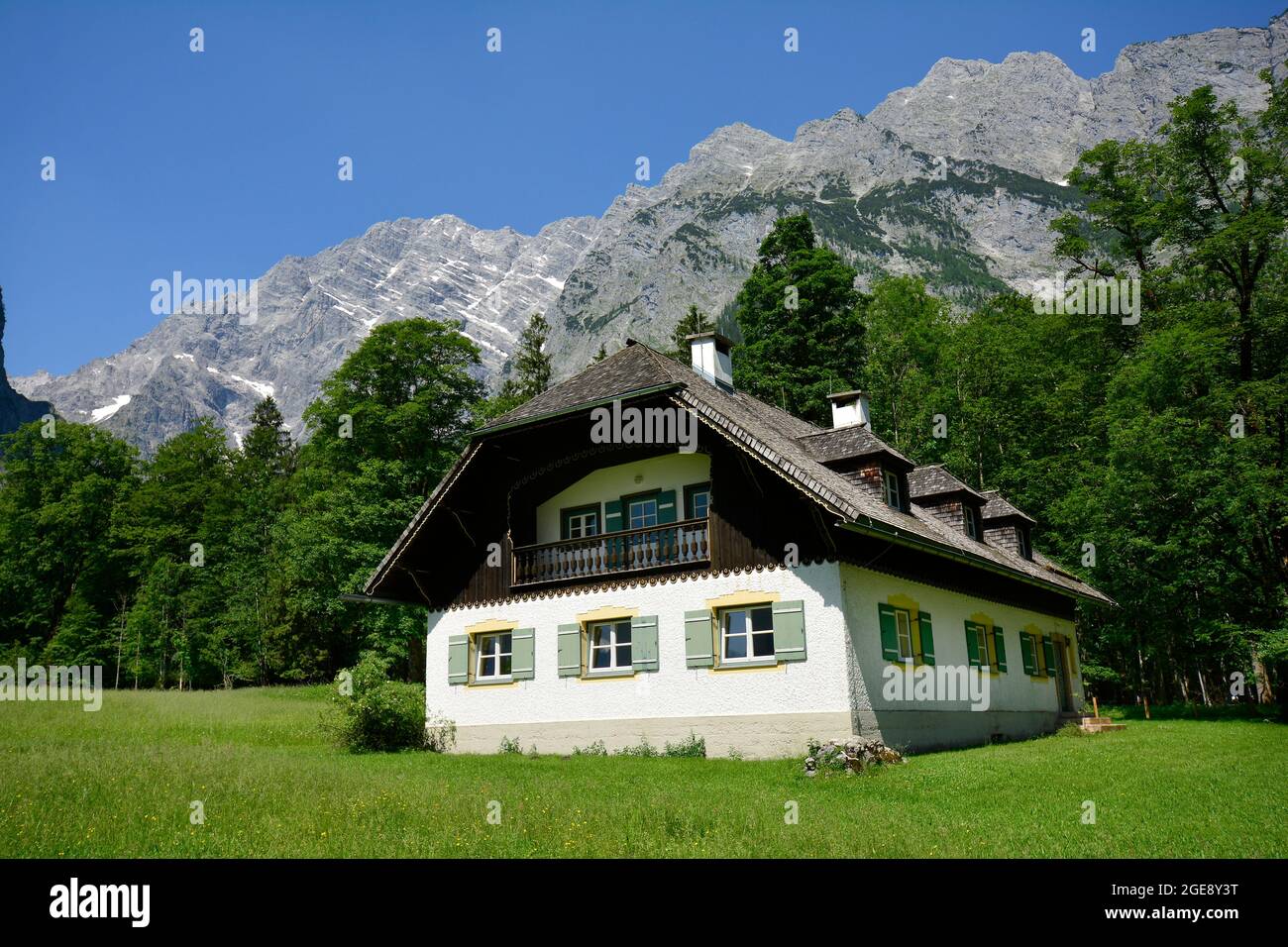 Germania, Baviera, casa vicino Berchtesgaden in stile architettonico tradizionale con i Monti Watzmann sullo sfondo Foto Stock