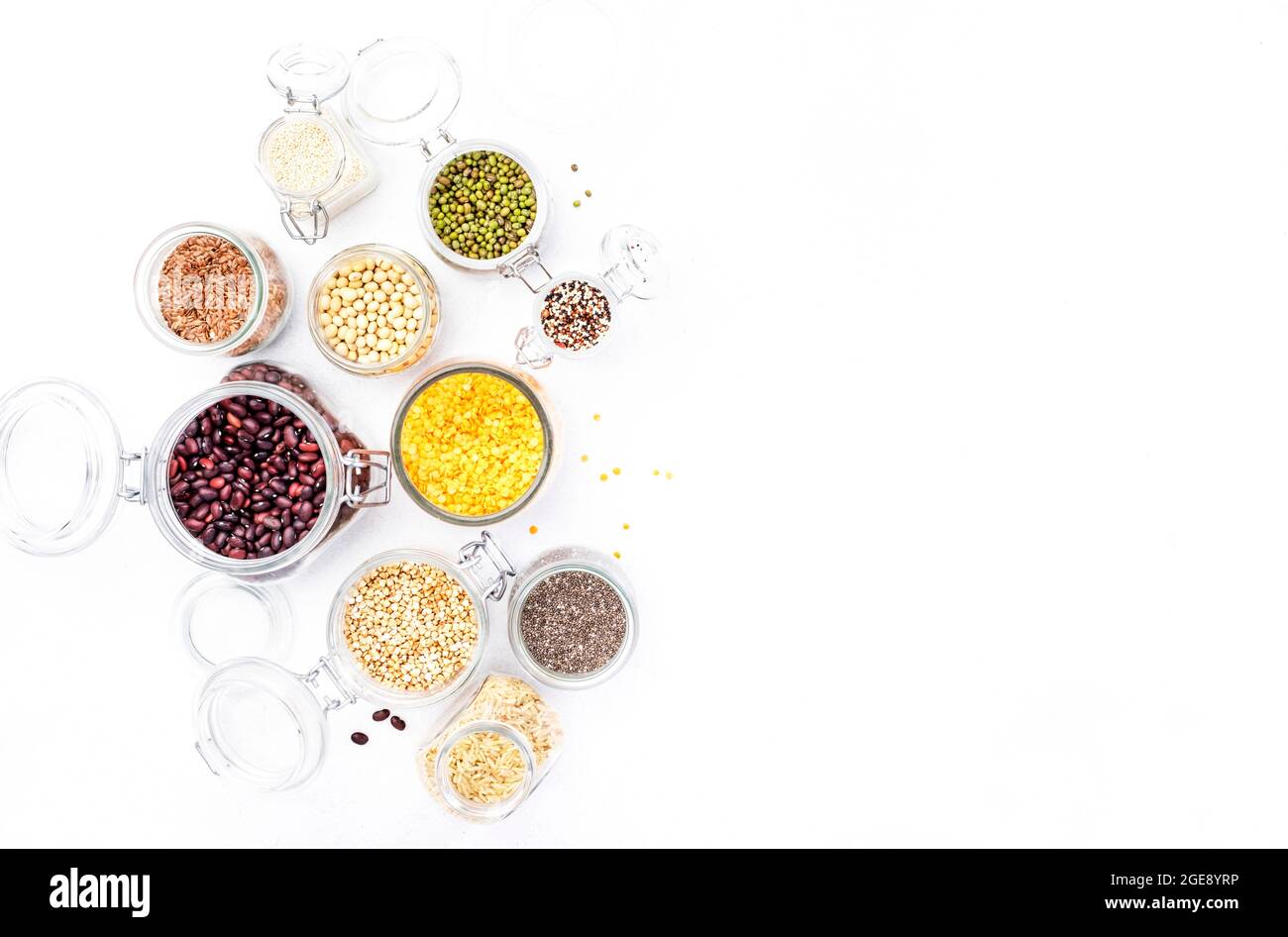 Drogheria, scorte domestiche in plastica di deposito libero e vasi. Fagioli vari, grani, cereali, legumi, semi in lattine riutilizzabili. Tavola bianca. Zero rifiuti e su Foto Stock