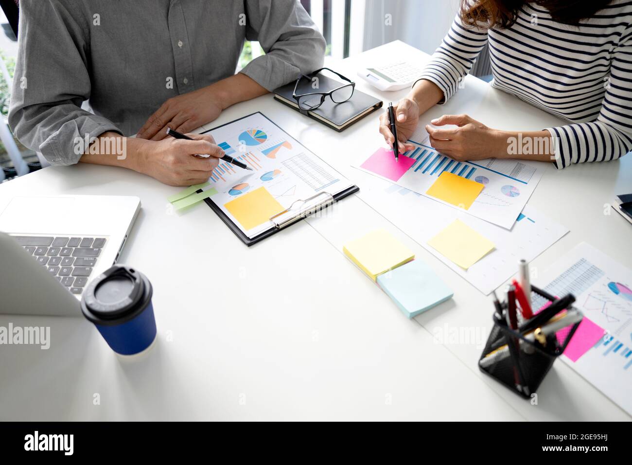 La giovane donna di affari sta spiegando i programmi di affari al team del personale per il commercio di startup con il grafico e il grafico nella riunione di programma di vendita. Foto Stock