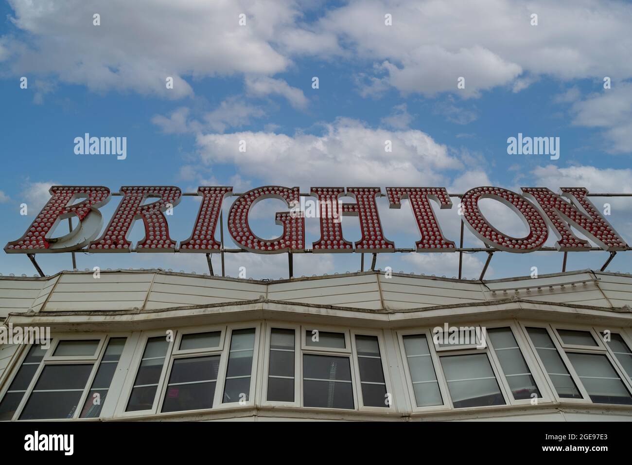 Un segno che legge Brighton con un cielo blu e le nuvole sullo sfondo Foto Stock