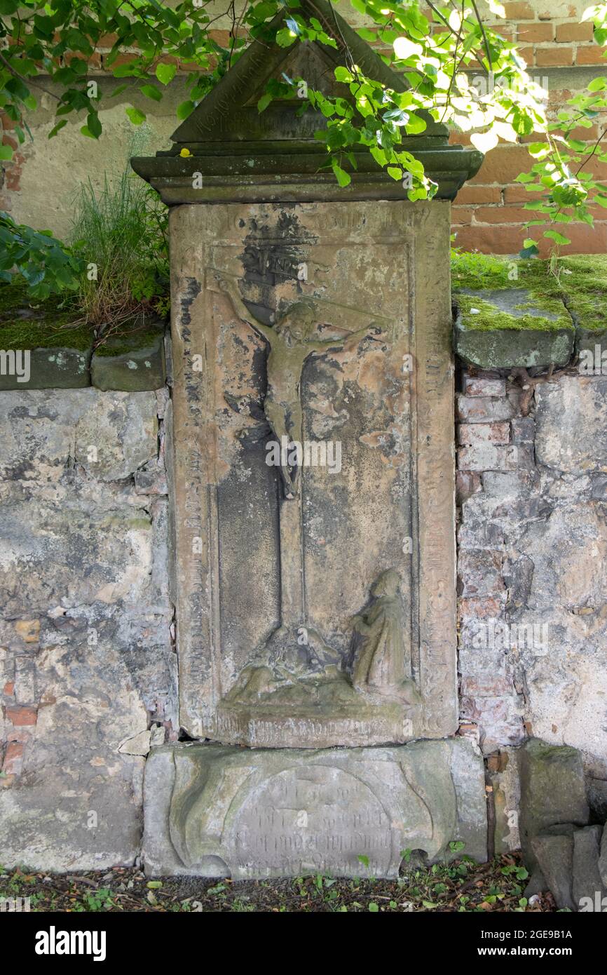 Una lapide barocca con Gesù crocifisso nel muro del cimitero Foto Stock