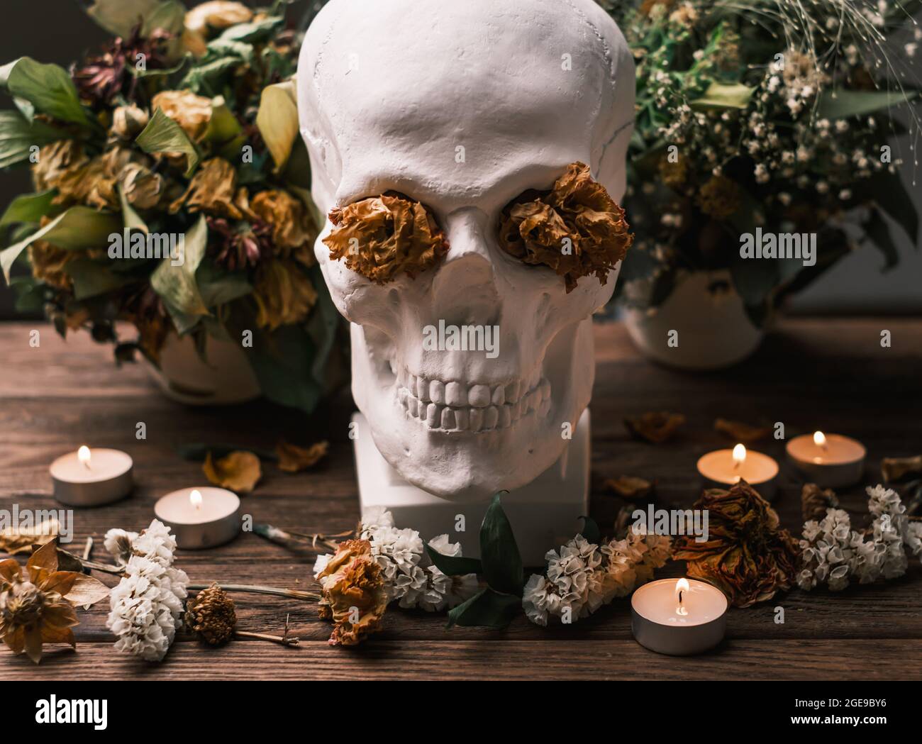 Mazzi di fiori selvaggi sul tavolo e un teschio al centro. Foto Stock
