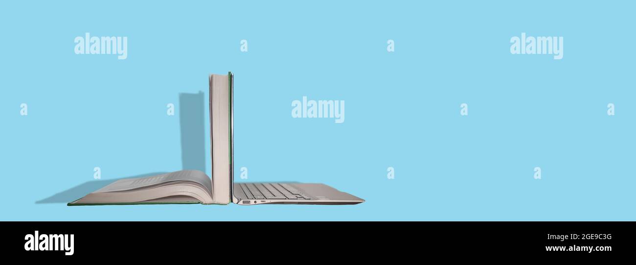Banner con un computer portatile moderno posizionato da dietro a dietro con un folto libro aperto. Concetto per l'istruzione dell'era digitale, l'apprendimento a distanza e la scolarizzazione. Foto Stock