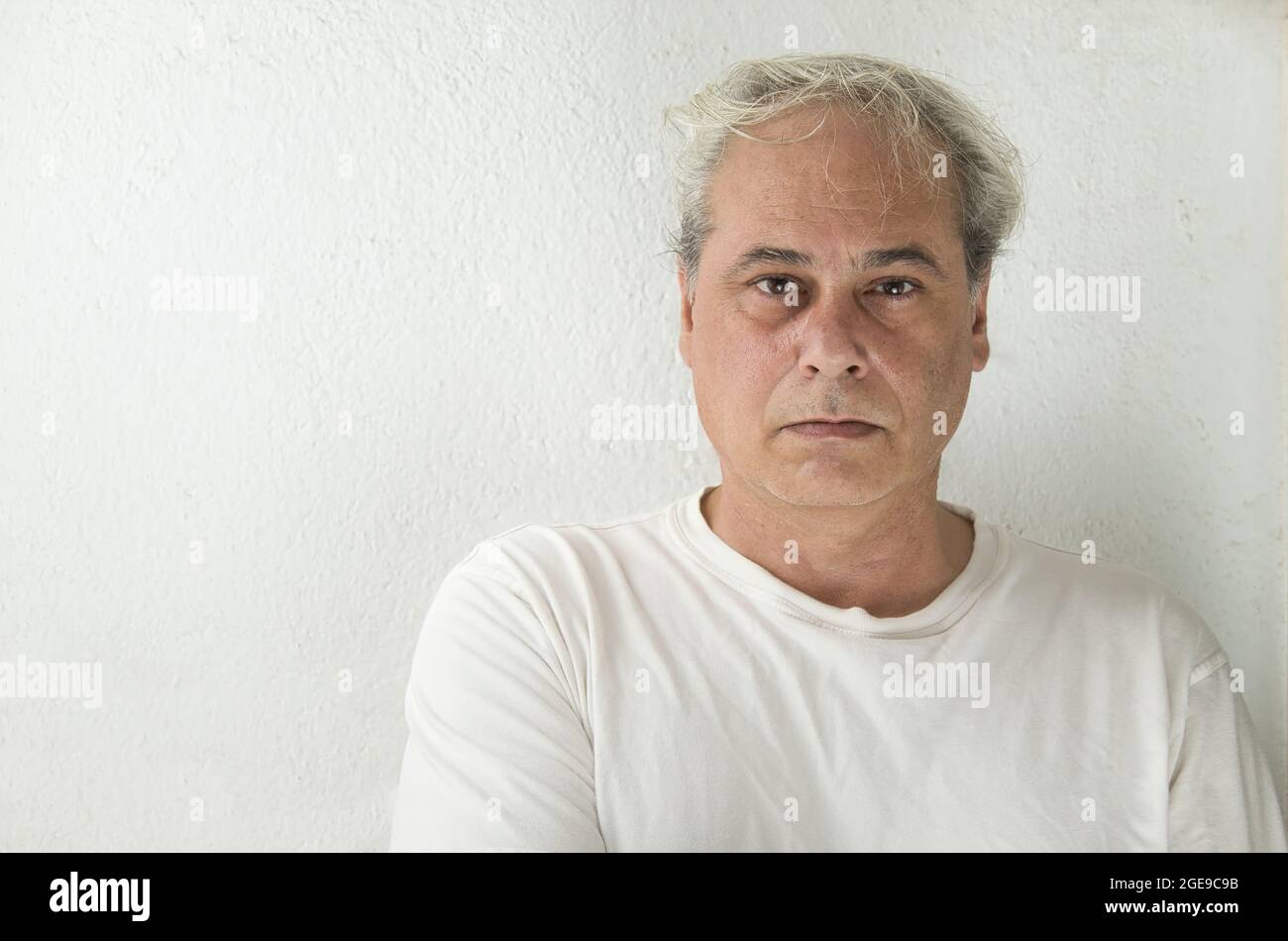 ritratto di uomo maturo con capelli grigi in camicia bianca su sfondo bianco Foto Stock