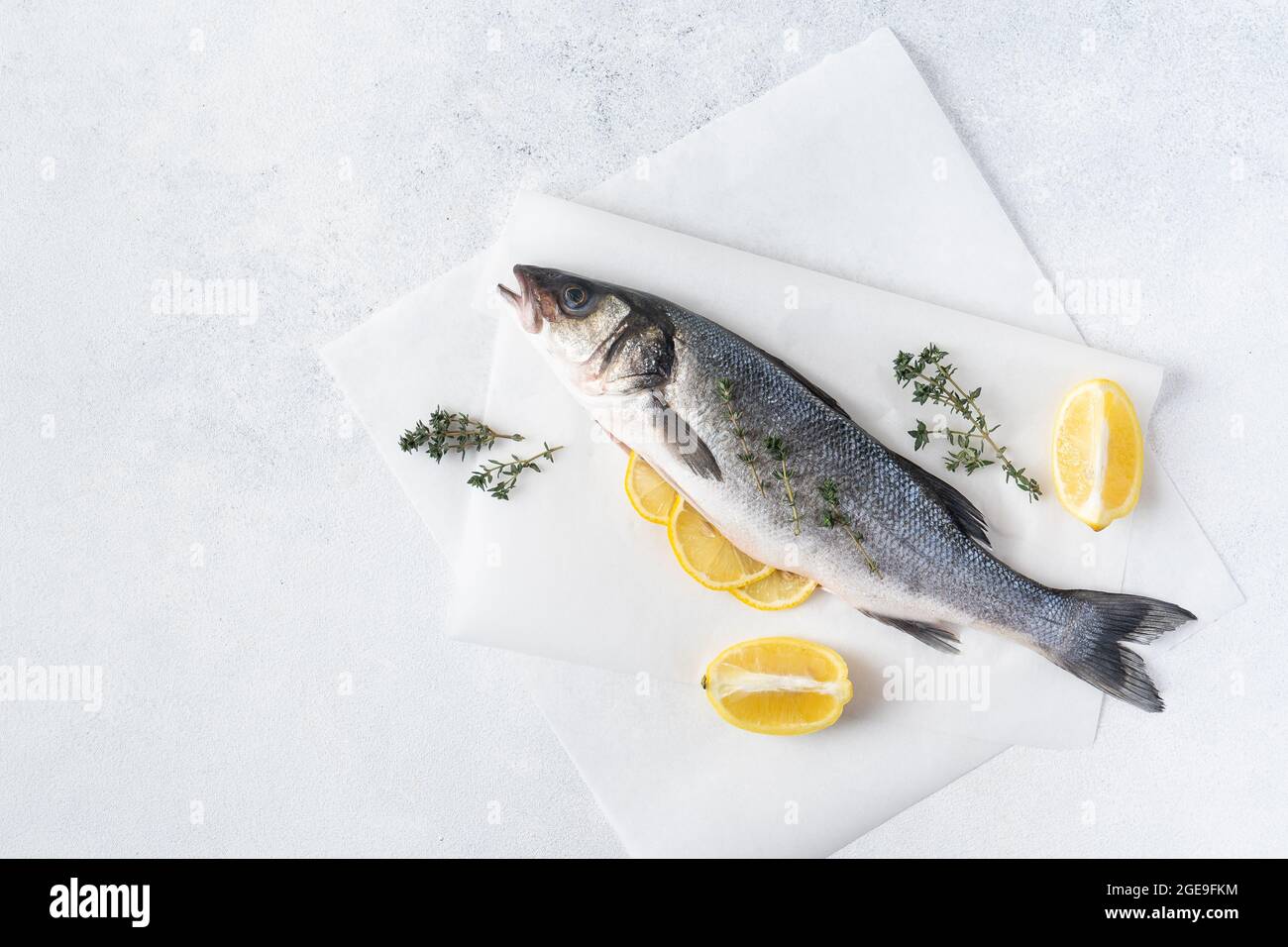 Pesce fresco crudo con spezie. Ingredienti per cucinare o grigliare sul tagliere Foto Stock