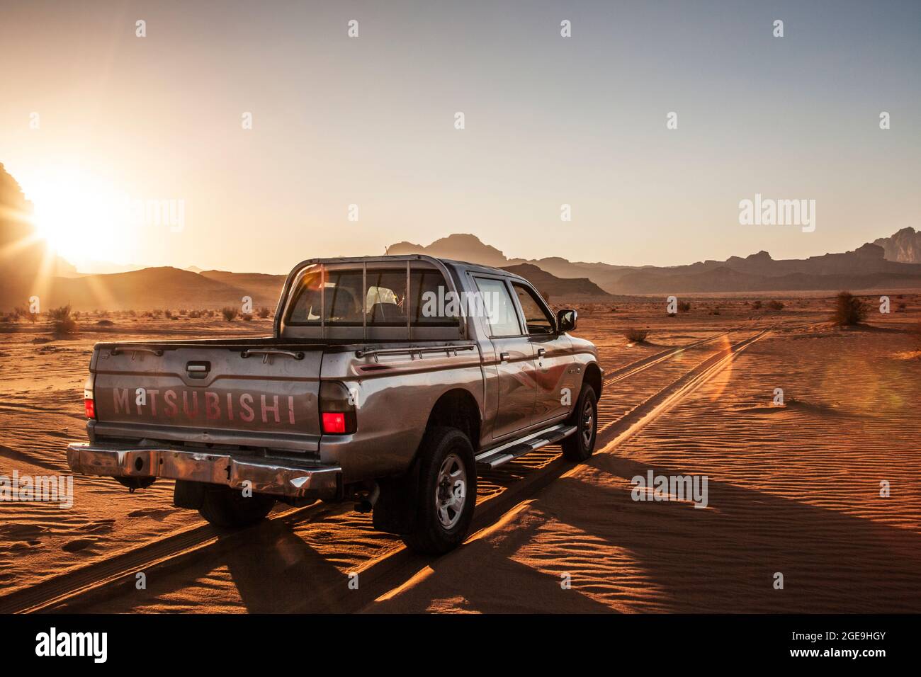 Un turista Mitsubishi jeep al tramonto nel deserto giordano a Wadi Rum o a valle della luna. Foto Stock